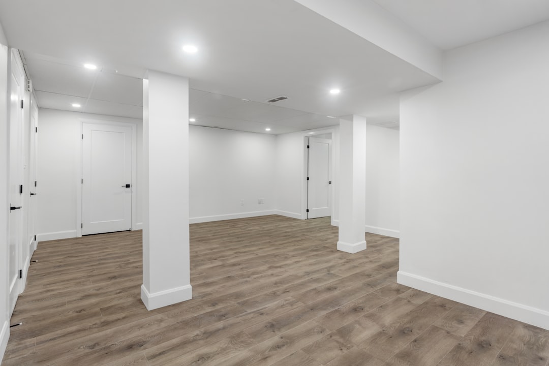 an-empty-room-with-white-walls-and-wooden-floors-tcnhgp7nf5i